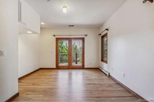 unfurnished room featuring baseboard heating, french doors, and light wood-type flooring