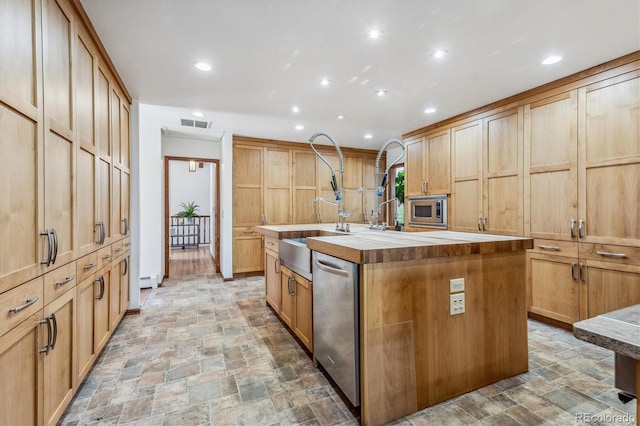 kitchen with a center island with sink, appliances with stainless steel finishes, and a baseboard radiator