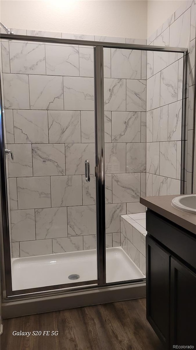 bathroom with vanity, hardwood / wood-style floors, and a shower with shower door