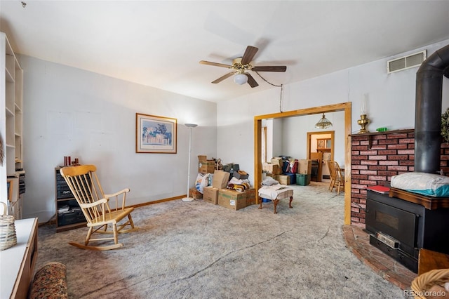 2402 W Uintah St, Colorado Springs, CO 80904 - sitting room featuring a wood stove, ceiling fan, and carpet floors