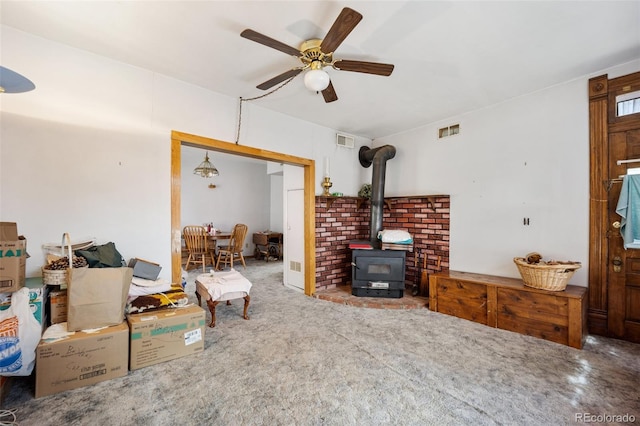 2402 W Uintah St, Colorado Springs, CO 80904 - living room featuring a wood stove, ceiling fan, and carpet floors