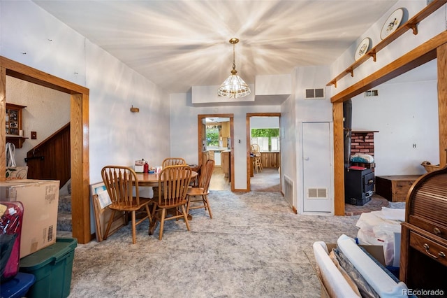 2402 W Uintah St, Colorado Springs, CO 80904 - dining area with carpet, a chandelier, and a wood stove