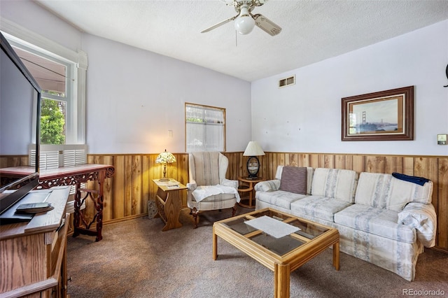 2402 W Uintah St, Colorado Springs, CO 80904 - carpeted living room with plenty of natural light, a wainscoted wall, wood walls, ceiling fan, and a textured ceiling