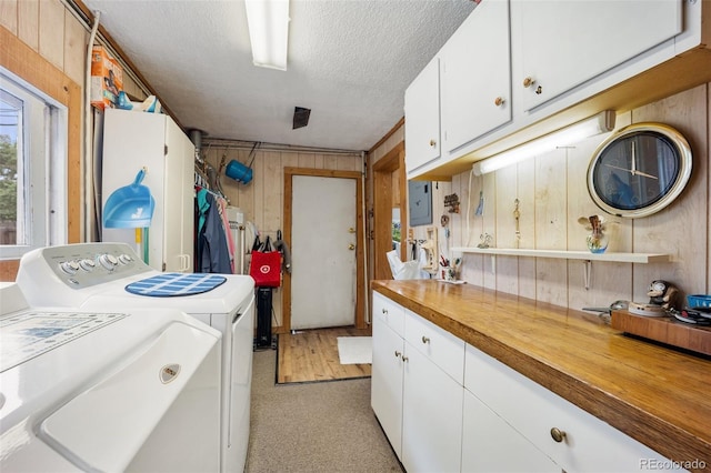 2402 W Uintah St, Colorado Springs, CO 80904 - laundry area with washing machine and clothes dryer, wood walls, a textured ceiling, and cabinet space