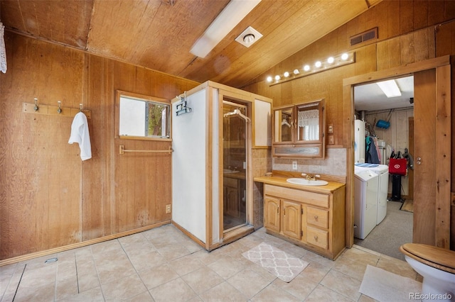 2402 W Uintah St, Colorado Springs, CO 80904 - bathroom with vaulted ceiling, washing machine and clothes dryer, wooden walls, vanity, and wooden ceiling