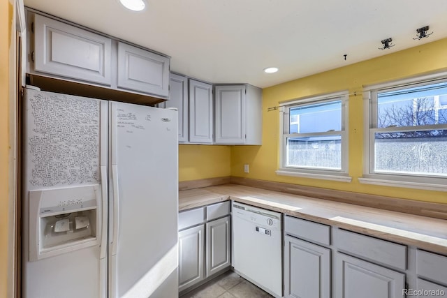 kitchen featuring light tile patterned floors, gray cabinetry, and white appliances