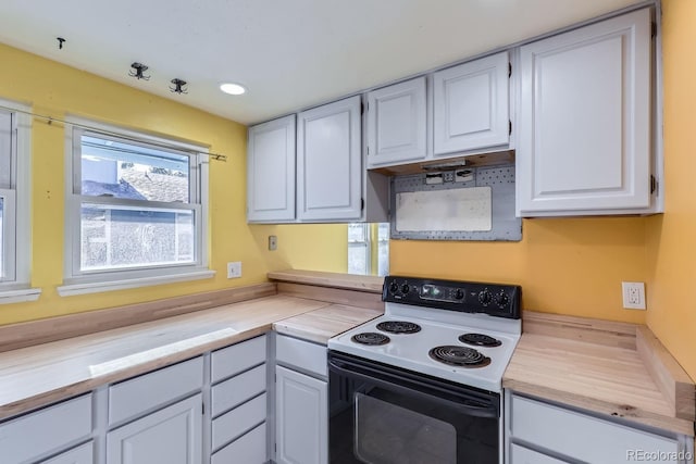 kitchen featuring white cabinetry and electric range