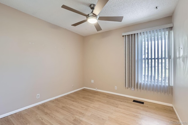 spare room featuring ceiling fan, a textured ceiling, and light hardwood / wood-style flooring