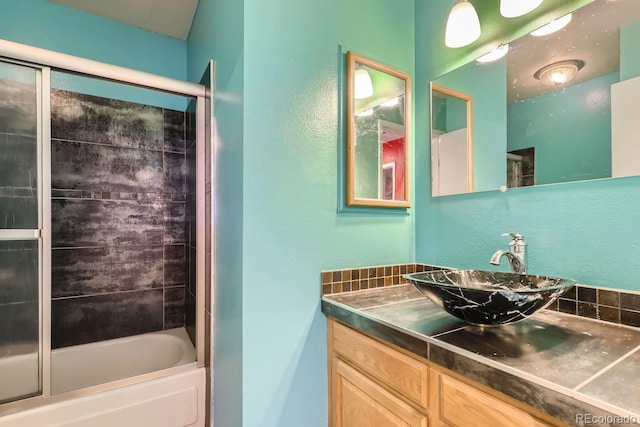 bathroom featuring tiled shower / bath combo and vanity