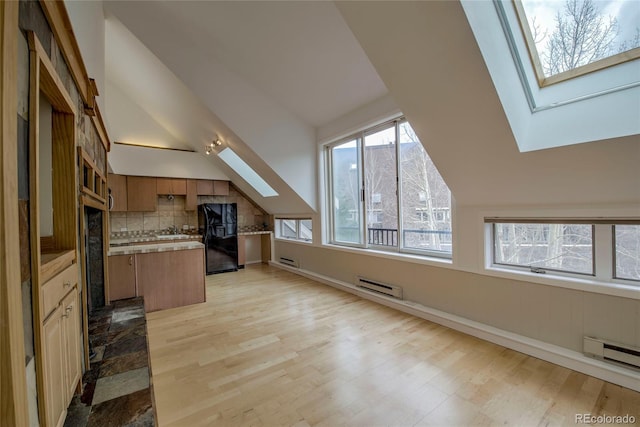 21650 US Highway 6 Unit 2096, Dillon, CO 80435 - kitchen with a skylight, black fridge with ice dispenser, a baseboard radiator, a kitchen island, and lofted ceiling