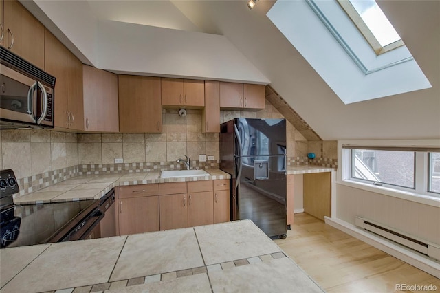 21650 US Highway 6 Unit 2096, Dillon, CO 80435 - kitchen featuring black appliances, lofted ceiling, a skylight, light wood-style flooring, and tasteful backsplash