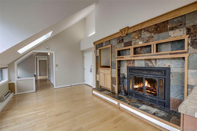 21650 US Highway 6 Unit 2096, Dillon, CO 80435 - unfurnished living room with a skylight, wood finished floors, high vaulted ceiling, a fireplace, and a baseboard radiator