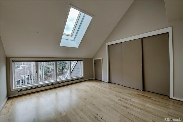 21650 US Highway 6 Unit 2096, Dillon, CO 80435 - unfurnished bedroom with a skylight, baseboard heating, lofted ceiling, light wood finished floors, and a closet