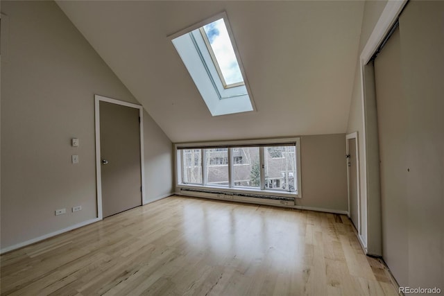 21650 US Highway 6 Unit 2096, Dillon, CO 80435 - unfurnished room featuring a baseboard heating unit, lofted ceiling, a skylight, and light wood-style floors