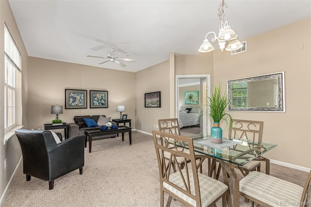 dining space featuring light carpet, visible vents, ceiling fan with notable chandelier, and baseboards