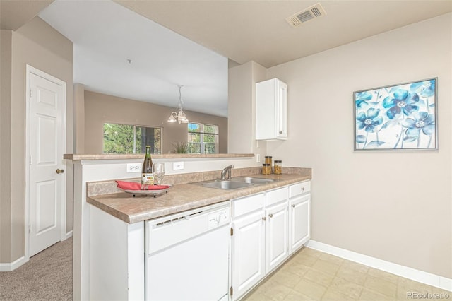 kitchen with visible vents, a peninsula, white dishwasher, a sink, and white cabinetry