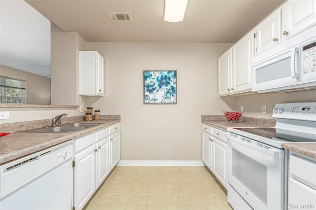 kitchen with visible vents, white cabinets, white appliances, and a sink