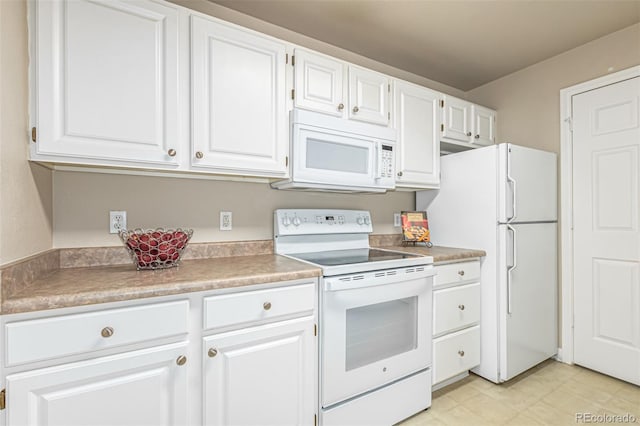 kitchen with white appliances, light countertops, and white cabinetry