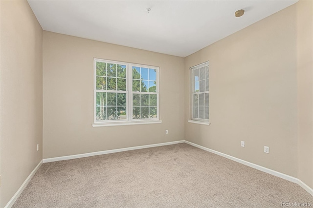 empty room featuring baseboards and carpet floors