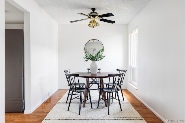 9453 W Utah Pl, Lakewood, CO 80232 - dining room with wood finished floors, a textured ceiling, ceiling fan, and baseboards