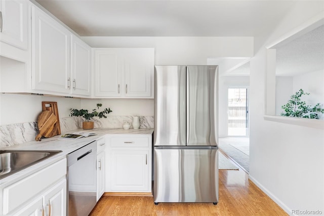 9453 W Utah Pl, Lakewood, CO 80232 - kitchen featuring appliances with stainless steel finishes, light wood-type flooring, and white cabinetry
