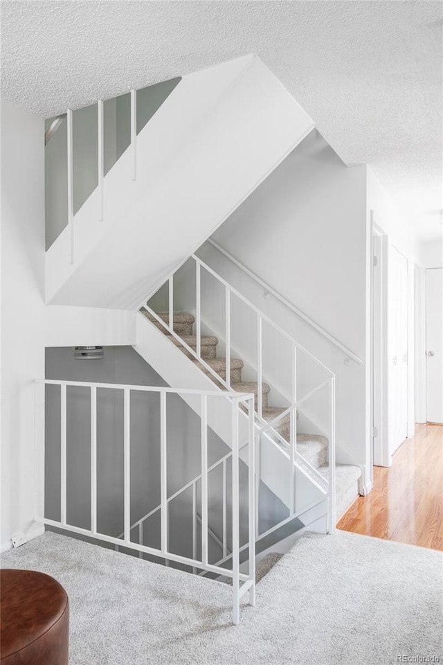 9453 W Utah Pl, Lakewood, CO 80232 - stairs with a textured ceiling, carpet floors, and wood finished floors