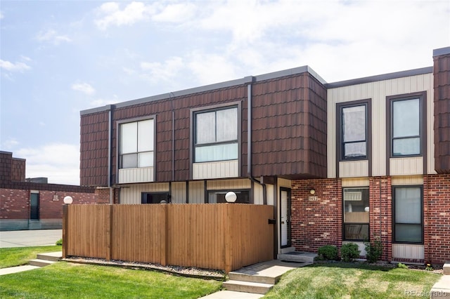 9453 W Utah Pl, Lakewood, CO 80232 - townhome / multi-family property with fence, brick siding, and mansard roof