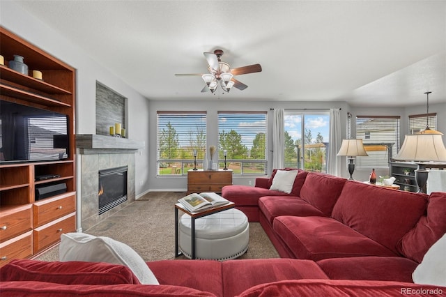 carpeted living room with a fireplace, a ceiling fan, and baseboards