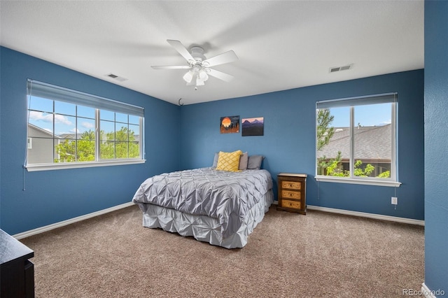 bedroom featuring multiple windows, carpet flooring, baseboards, and a ceiling fan