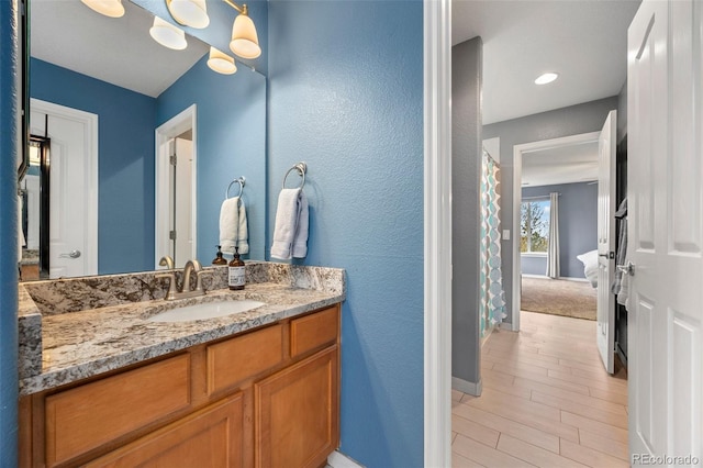 full bathroom featuring baseboards, vanity, and wood finished floors