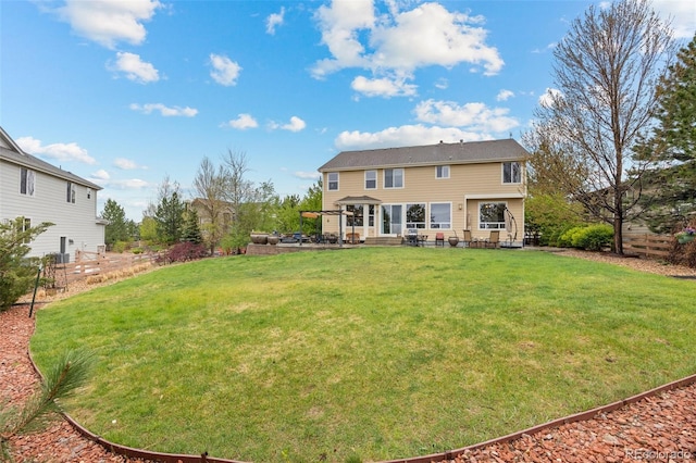 back of property with a yard and a patio