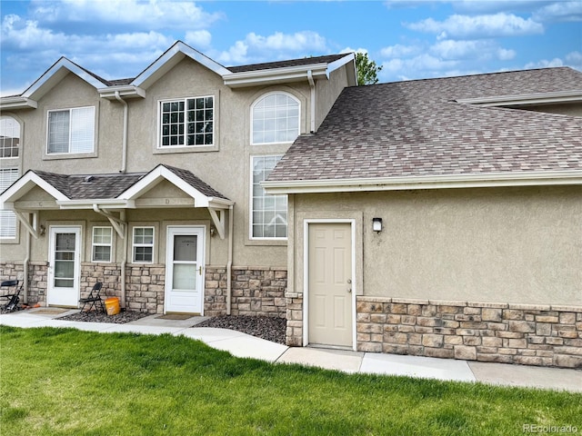 2247 Coronado Pkwy N # D, Denver, CO 80229 - townhome / multi-family property featuring stucco siding, stone siding, a shingled roof, and a front lawn