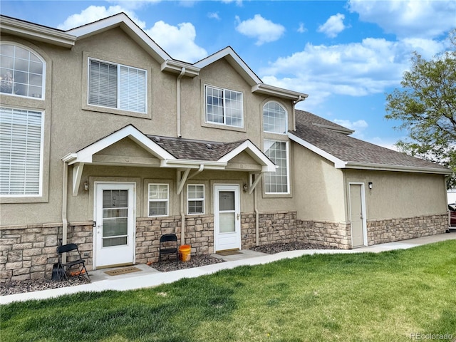 2247 Coronado Pkwy N # D, Denver, CO 80229 - view of front of home featuring stucco siding, stone siding, a front yard, and roof with shingles