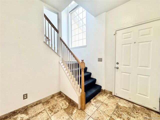 2247 Coronado Pkwy N # D, Denver, CO 80229 - entryway with stairway, baseboards, and light stone finish floors
