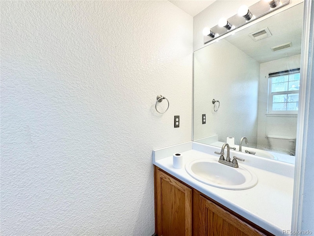 2247 Coronado Pkwy N # D, Denver, CO 80229 - half bathroom featuring a textured wall, vanity, and toilet