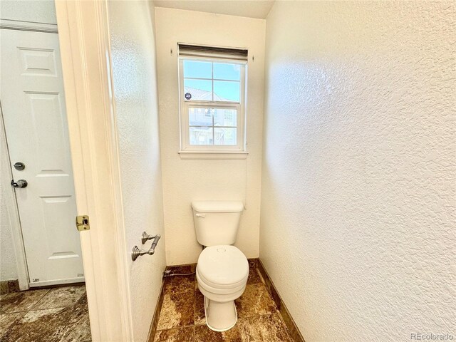 2247 Coronado Pkwy N # D, Denver, CO 80229 - bathroom with baseboards, a textured wall, and toilet