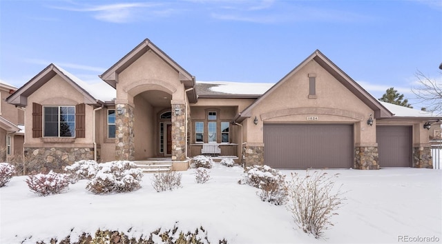 view of front facade featuring stone siding, an attached garage, and stucco siding