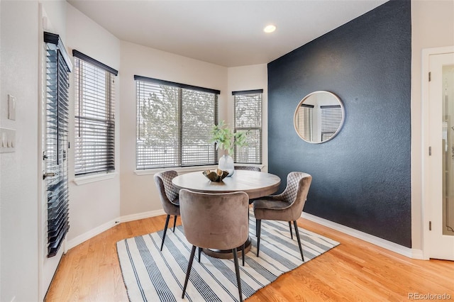 dining area featuring light wood-type flooring and baseboards