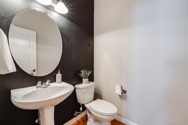 bathroom featuring toilet and baseboards