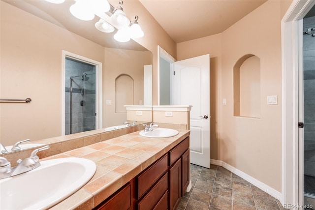 full bathroom featuring a sink, baseboards, and double vanity