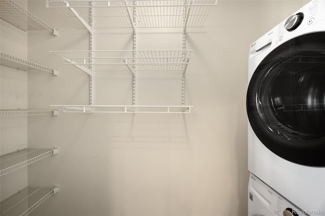 clothes washing area with stacked washer and dryer