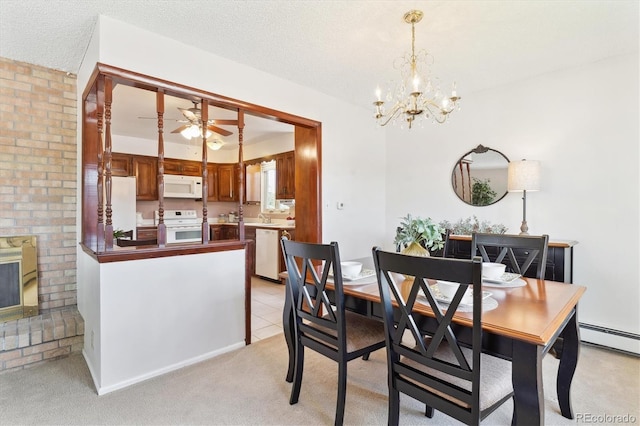 3298 Quail St, Wheat Ridge, CO 80033 - dining space with a chandelier, a baseboard heating unit, ceiling fan, light carpet, and a brick fireplace