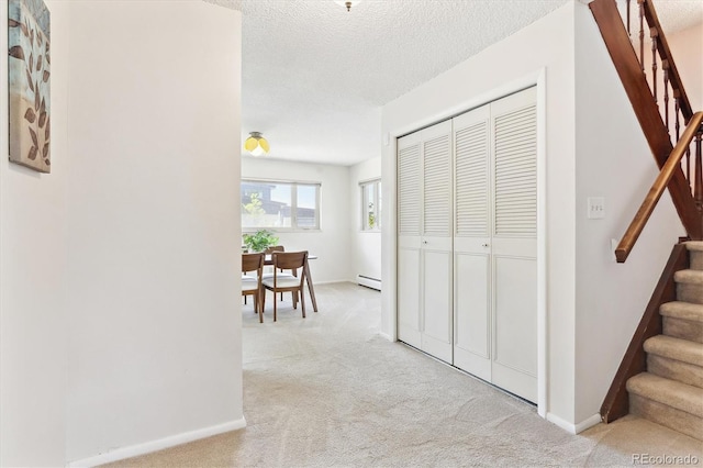 3298 Quail St, Wheat Ridge, CO 80033 - hallway with stairway, light carpet, baseboard heating, baseboards, and a textured ceiling