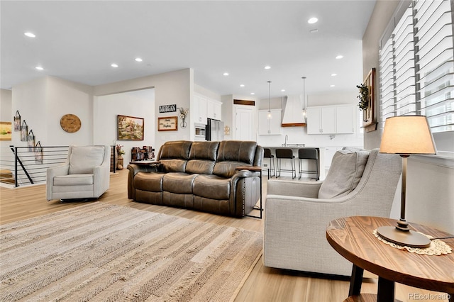 living area featuring light wood-type flooring and recessed lighting