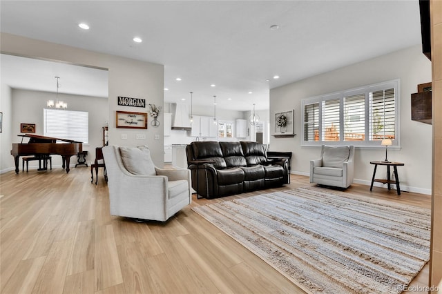 living area featuring light wood-type flooring, a chandelier, baseboards, and recessed lighting