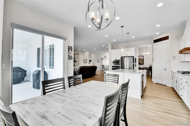 dining room featuring an inviting chandelier, recessed lighting, and light wood-style flooring