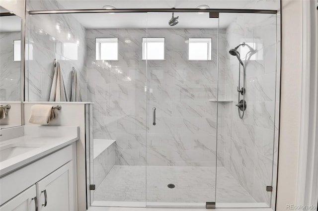 bathroom with a shower stall, vanity, and a healthy amount of sunlight