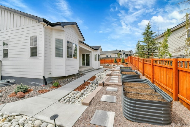 exterior space with a vegetable garden and a fenced backyard