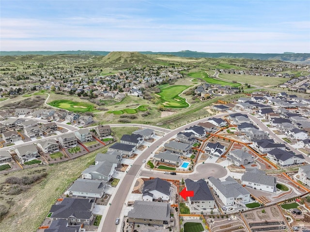 drone / aerial view featuring a mountain view, golf course view, and a residential view