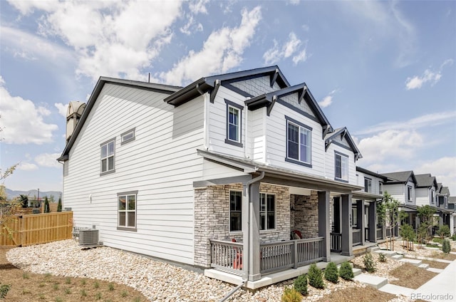 5099 S Robb St, Littleton, CO 80127 - view of home's exterior featuring central air condition unit, stone siding, a porch, and a residential view
